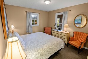 A bedroom with a bed, dresser, chair, and a mirror on the wall. - Fully Furnished Camping Cabin near Cherokee National Forest (Greeneville)