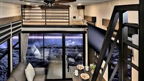 Ein modernes Interieur mit einer Couch, einem Esstisch und einer Treppe.