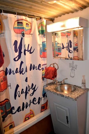 A bathroom with a shower curtain featuring colorful vehicles and the text 'You make me happy.' - Texas Hill Country Vintage Caravan Glamping (Marble Falls)