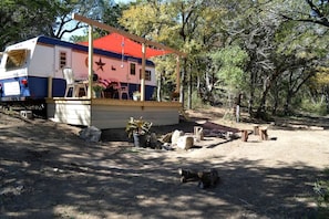 A mobile home with a porch, a star decoration, and potted plants. - Texas Hill Country Vintage Caravan Glamping (Marble Falls)