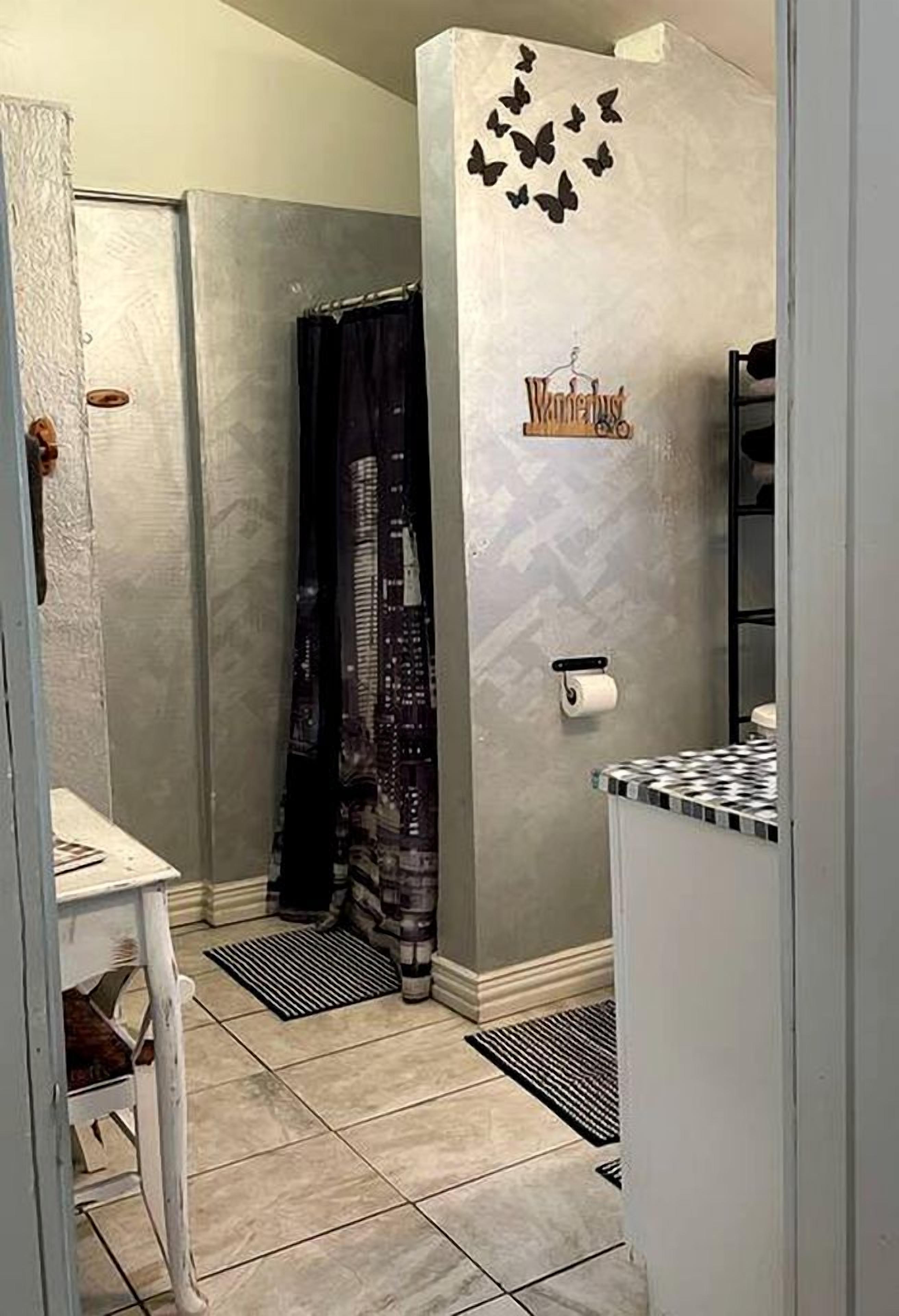 A bathroom with a shower, a toilet, a sink, and a towel rack.