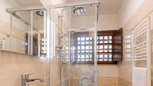 Une salle de bain moderne avec un grand lavabo blanc, une douche à parois de verre, des toilettes et un bidet.