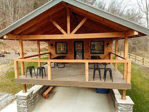Eine Holzhütte mit Veranda, zwei Fenstern und einer Tür.