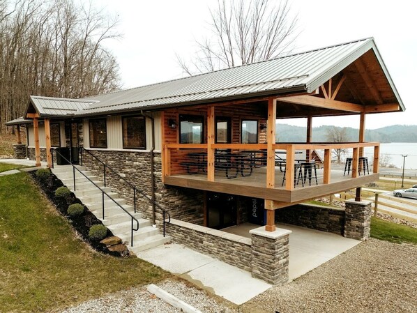 Eine Lodge mit Steinaußenwand, einer Holzterrasse und einer Sitzgelegenheit im Freien.