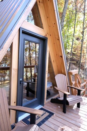 A wooden deck with a glass door and two Adirondack chairs. - Two Person A-frame near Tappan Lake, Ideal to Reconnect with Nature in Ohio (Deersville)