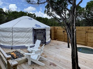 A covered outdoor area with a fire pit, white chairs, and a pool. - Peaceful Romantic Yurt with Hot Tub in Wimberley, Texas (Wimberley)