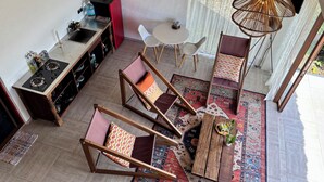 Une cuisine moderne équipée d’une cuisinière à gaz, d’un coin repas avec une table et des chaises, et d’un ventilateur de plafond.
