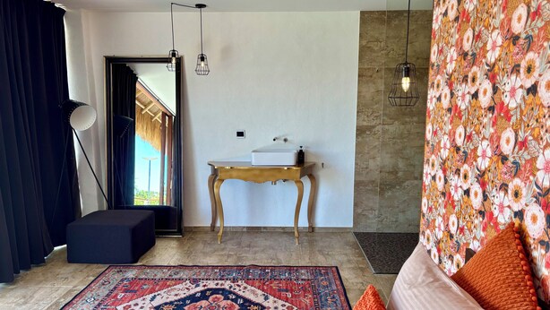 Un salon moderne avec un canapé, une table basse, un tapis et une vue sur l’extérieur.