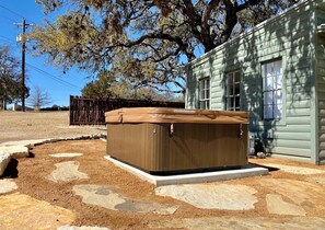 A hot tub in front of a house with a stone pathway. - Efficiency-Style Cabin with Spa Lovely for a Couples Escape in Hunt, Texas (Hunt)