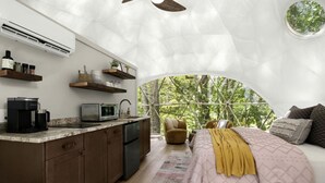 A cozy interior with a kitchen, a bed, and a view through a large window. - Outstanding Chic Dome with Private Deck in North Carolina (Creston)
