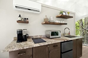 A modern kitchen with a built-in air conditioner, a coffee maker, a toaster, and a sink. - Outstanding Chic Dome with Private Deck in North Carolina (Creston)