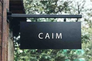 Een zwart bord met de tekst 'CAIM' in witte letters.