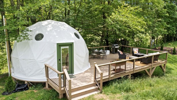 A dome-shaped tent with a wooden deck, outdoor furniture, and a grill. - Outstanding Chic Dome with Private Deck in North Carolina (Creston)