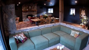 A cozy living area with a sectional sofa, a fireplace, a dining table, and a large window. - Cozy Yurt with Hot Tub Surrounded by Nature in Dripping Springs, Texas (Dripping Springs)