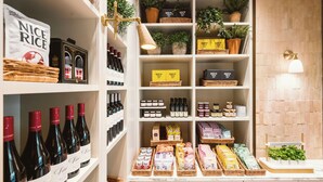 Un espace de vente bien aménagé, avec des étagères remplies de divers produits, notamment des bouteilles de vin, des boîtes de thé et des produits emballés.