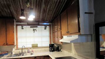 A kitchen with wooden cabinets, a stainless steel sink, and a built-in oven.