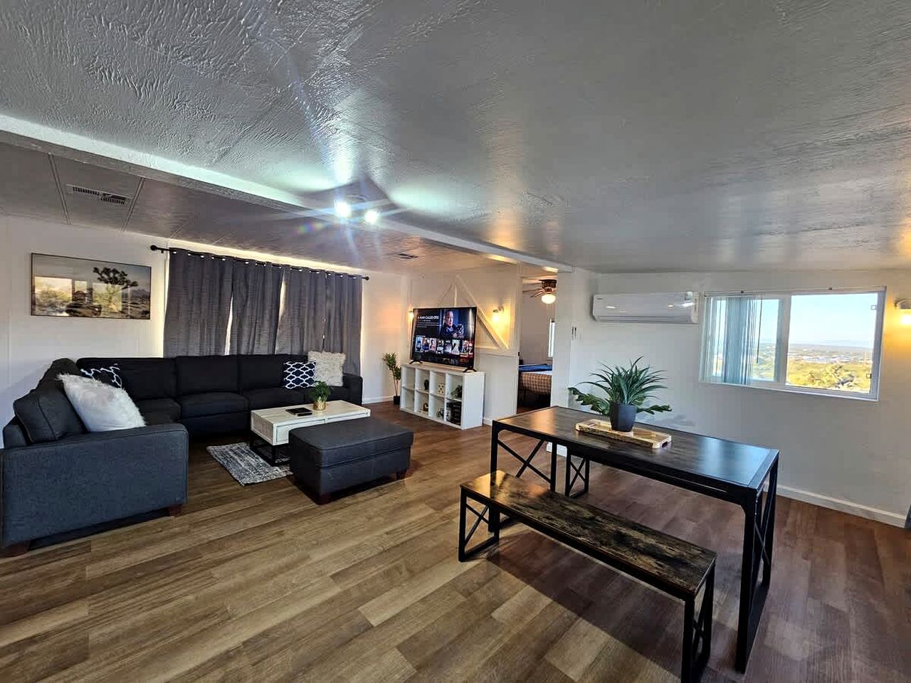 Een moderne woonkamer met een modulaire bank, een salontafel en een televisie.