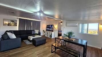 Een moderne woonkamer met een modulaire bank, een salontafel en een televisie.