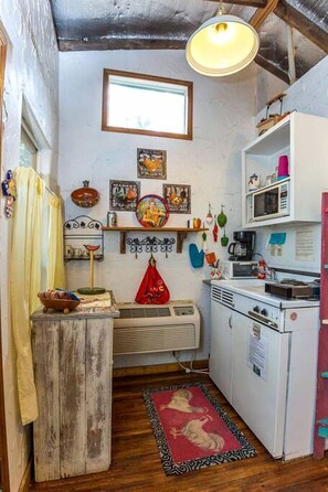 A compact kitchen with a vintage refrigerator, a microwave, and a small dining area.