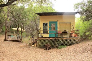 A small cabin with a porch, a door, and a window.