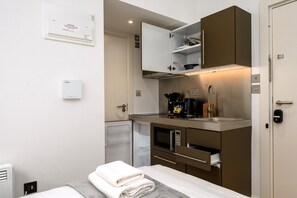 A compact kitchenette with a microwave, stove, and cabinets. - Guestready - Greenwich Park Studios (London)