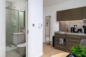 Un baño moderno con ducha acristalada, inodoro y lavabo.