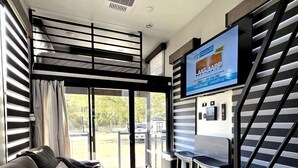 A modern interior with a sofa, a dining area, and a staircase.