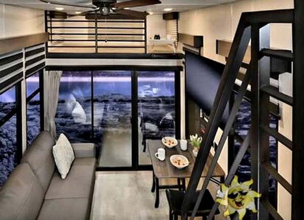 A modern interior with a sofa, dining table, and a staircase.