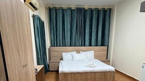 A room with a bed, a wardrobe, a desk, and a window with curtains. - Weekend Hotel (Beirut)