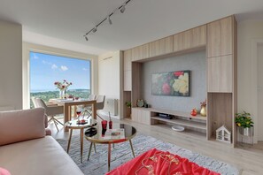 Appartamento Deluxe, 1 camera da letto, vista mare | Area soggiorno | TV a schermo piatto