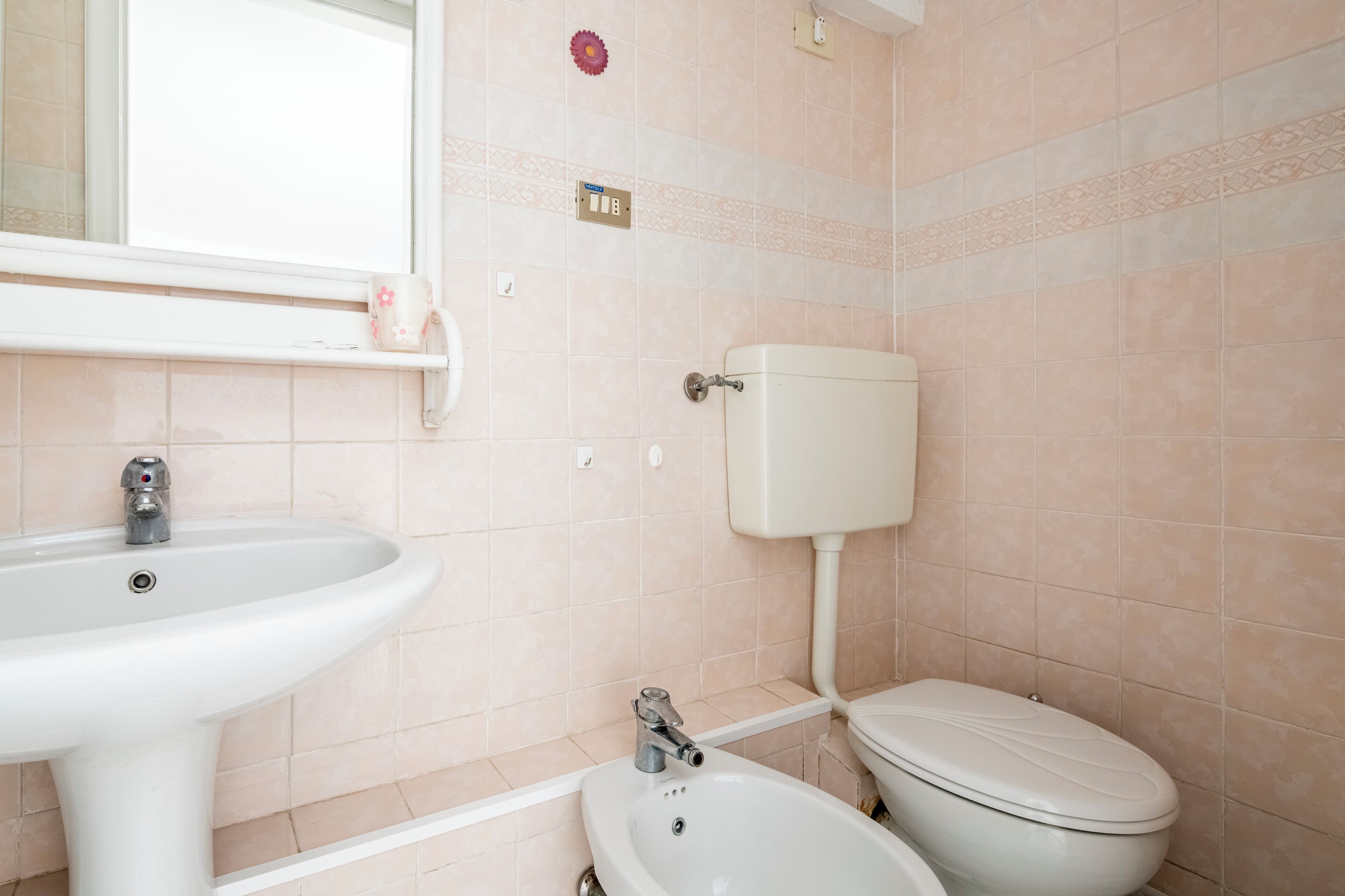Une salle de bain avec un lavabo, des toilettes et un miroir.