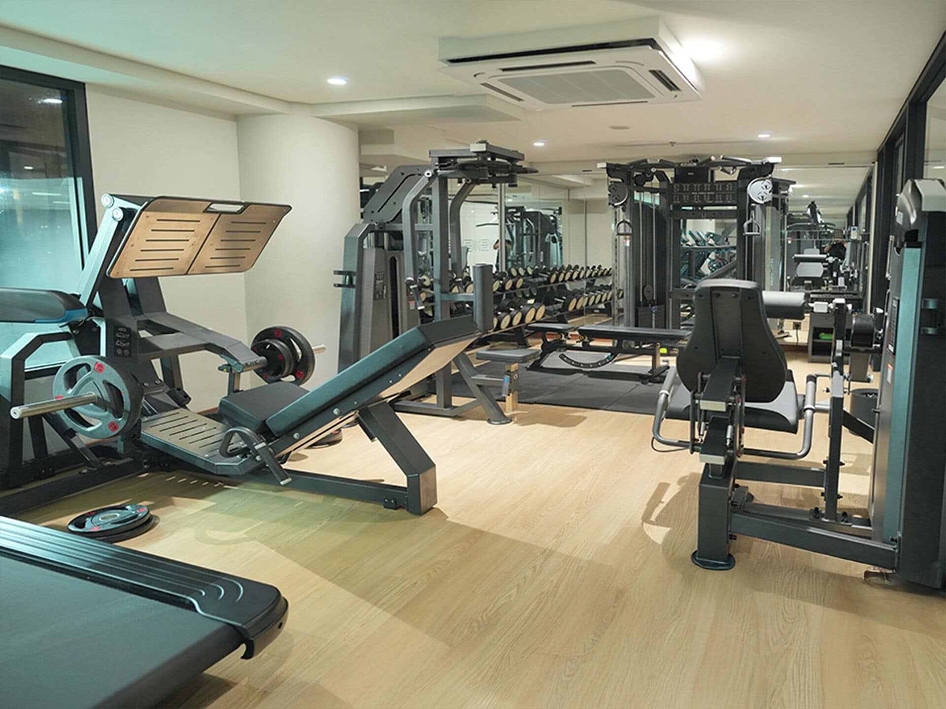 A gym with cardio equipment, weight machines, and free weights.