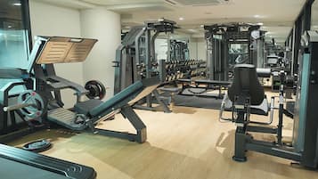 A gym with cardio equipment, weight machines, and free weights.