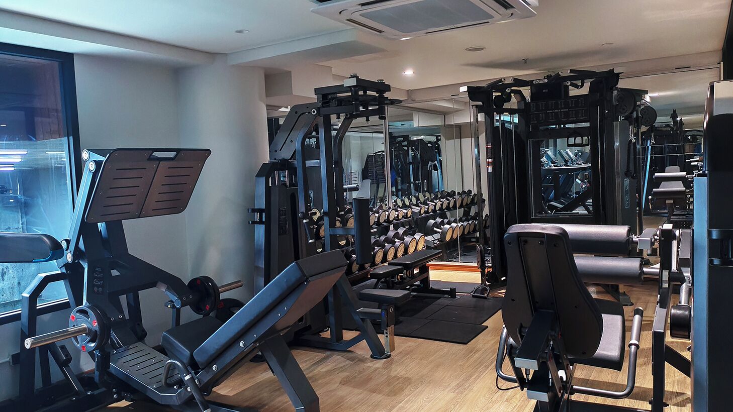 A gym with various exercise equipment, including weight machines and dumbbells.