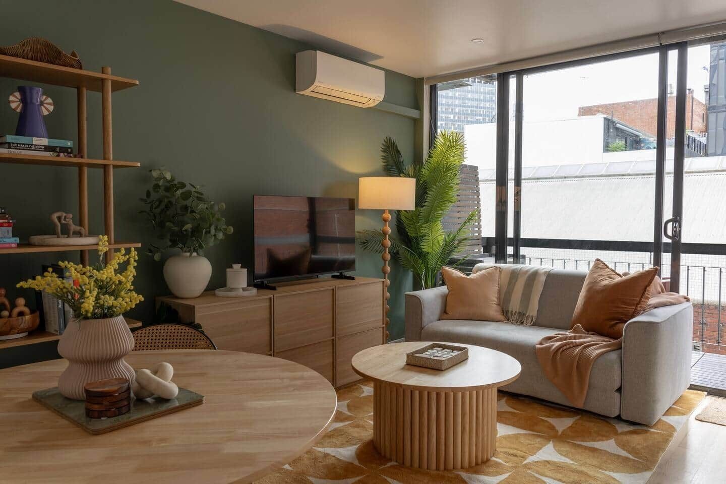 A modern living room with a sofa, a coffee table, a TV, and a bookshelf.