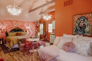 A bedroom with a bed, a desk, chairs, and a painting. - Experience the Magic of Our Original Family Cabin in Tracy City, TN (Tracy City)