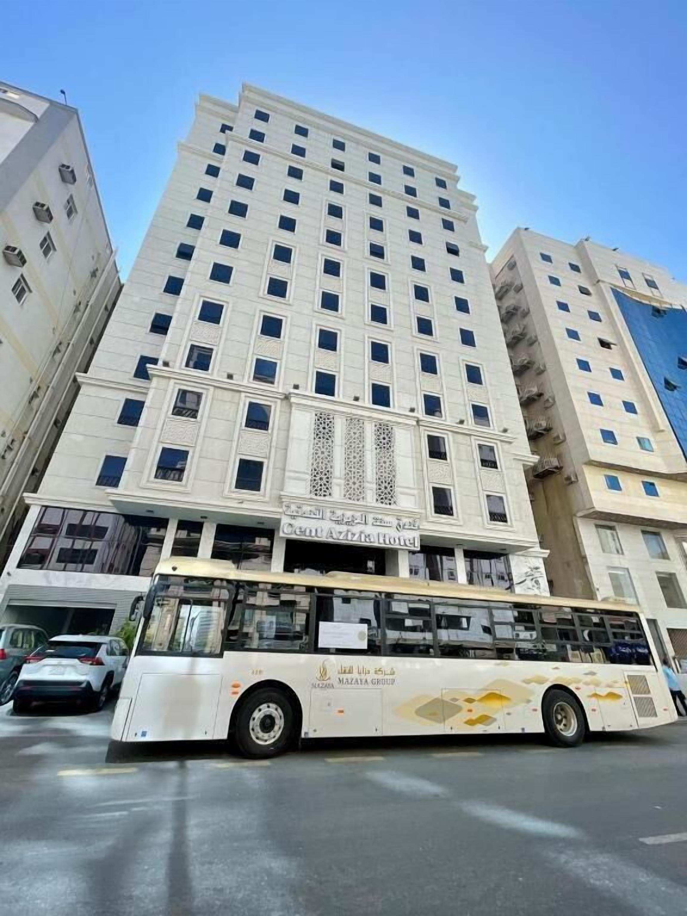 Ein mehrstöckiges Hotelgebäude mit einem auffälligen Schild für Ceno Azizia Hotel.