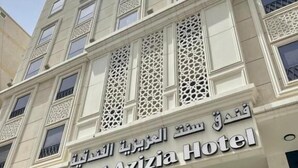 Un bâtiment d’hôtel avec une enseigne indiquant « CentAzizia Hotel ».