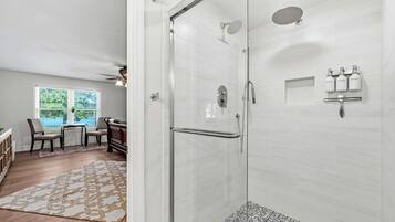 A modern bathroom with a glass shower enclosure, a toilet, and a sink.