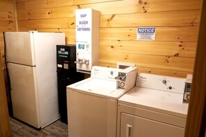 A laundry room with a refrigerator, a water dispenser, and a washing machine.
