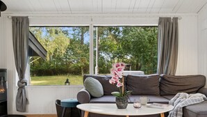 A cozy living room with a sofa, a coffee table, and a fireplace. - "Baarde" - 1.2km from the sea by Interhome (Vejby)