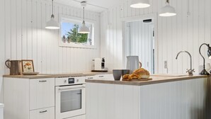 A modern kitchen with white cabinetry, a built-in oven, a large window, and pendant lighting. - "Baarde" - 1.2km from the sea by Interhome (Vejby)