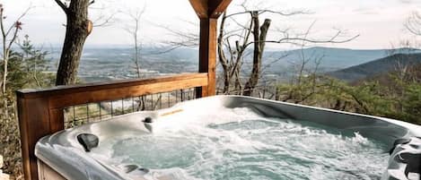 Ein Whirlpool mit Holzterrasse und Blick auf die Landschaft.