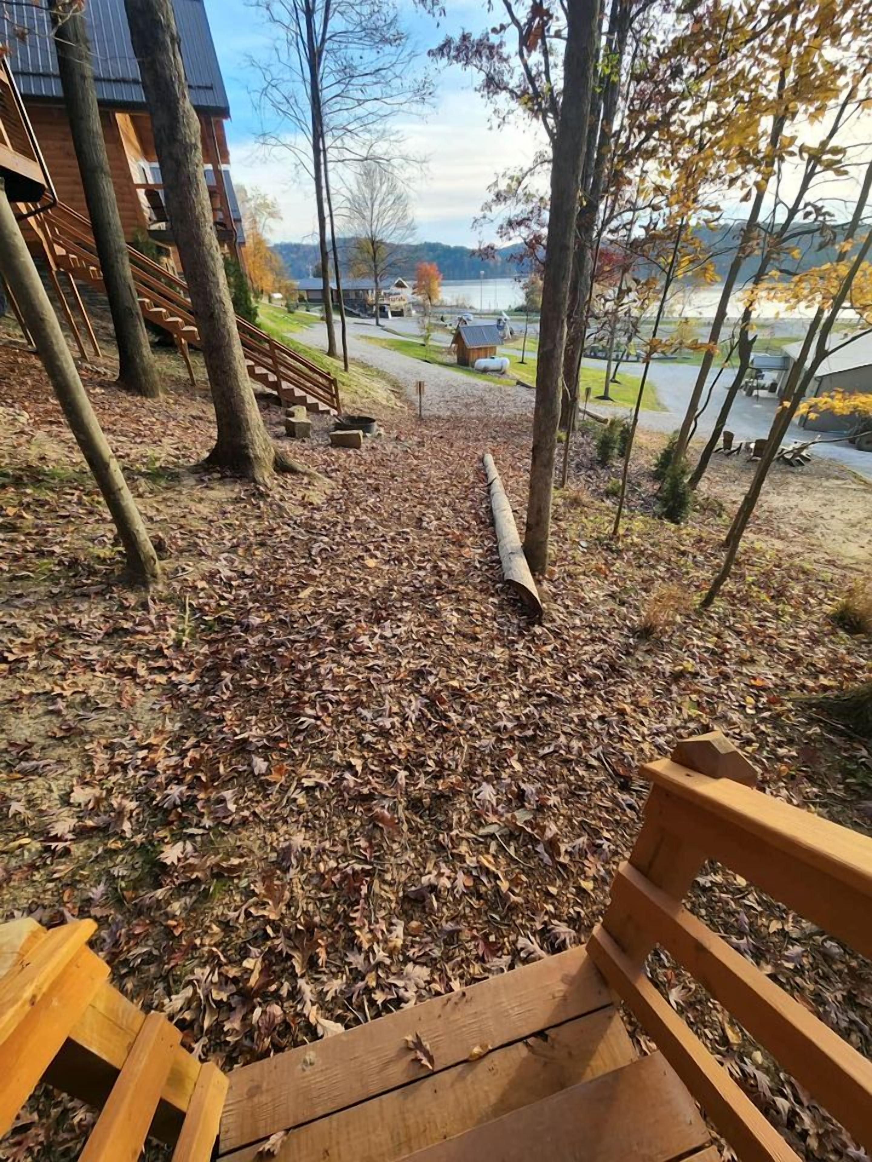 A wooden bench with a view of a lake and buildings in the background.