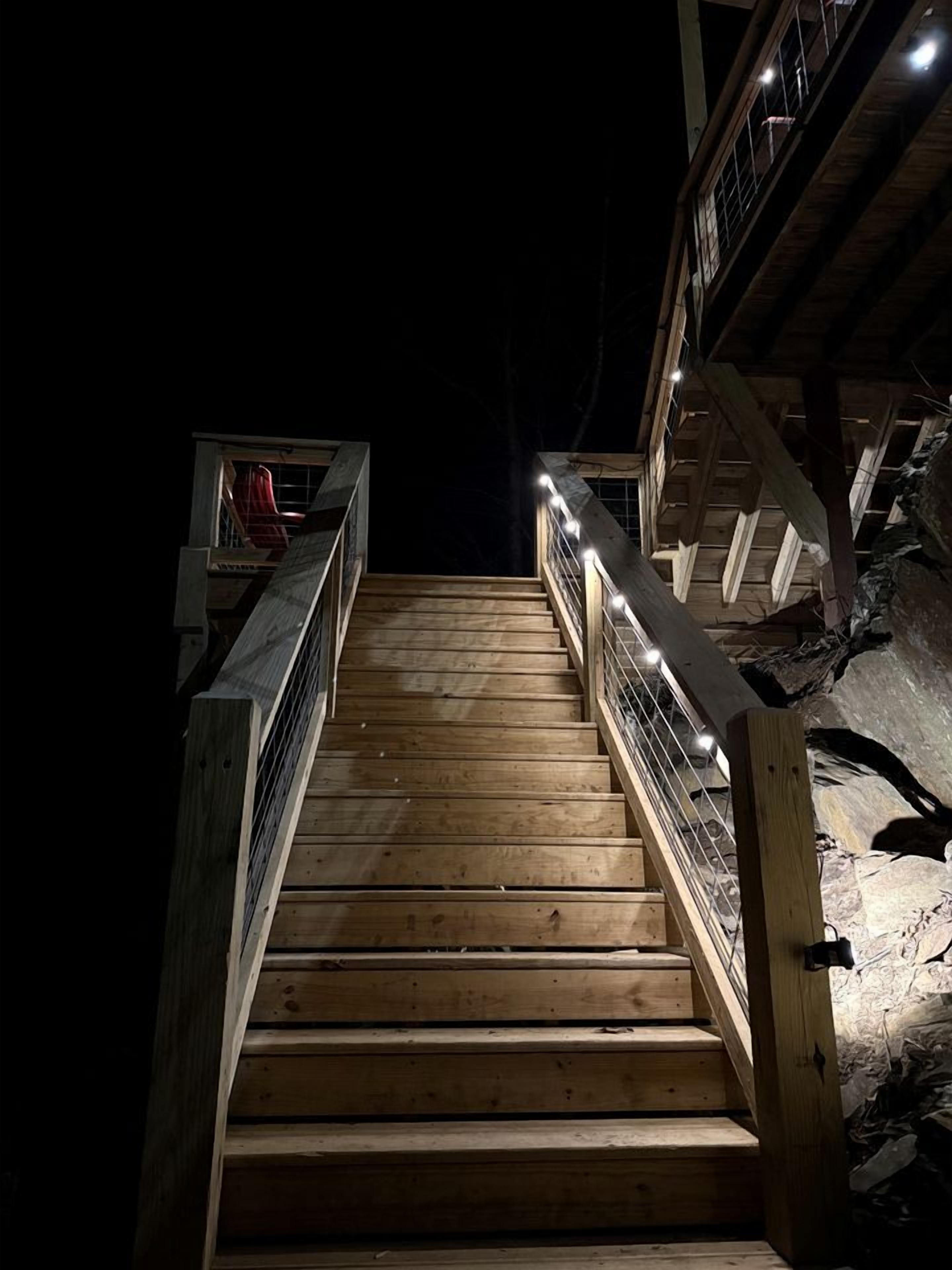 A wooden staircase with metal railings leading to a higher level.