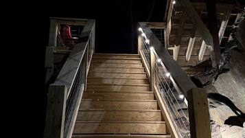 A wooden staircase with metal railings leading to a higher level.