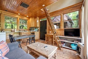 Interior de uma cabana com cozinha, sala de jantar e sala de estar.