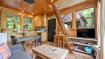 Interior de uma cabana com cozinha, sala de jantar e sala de estar.