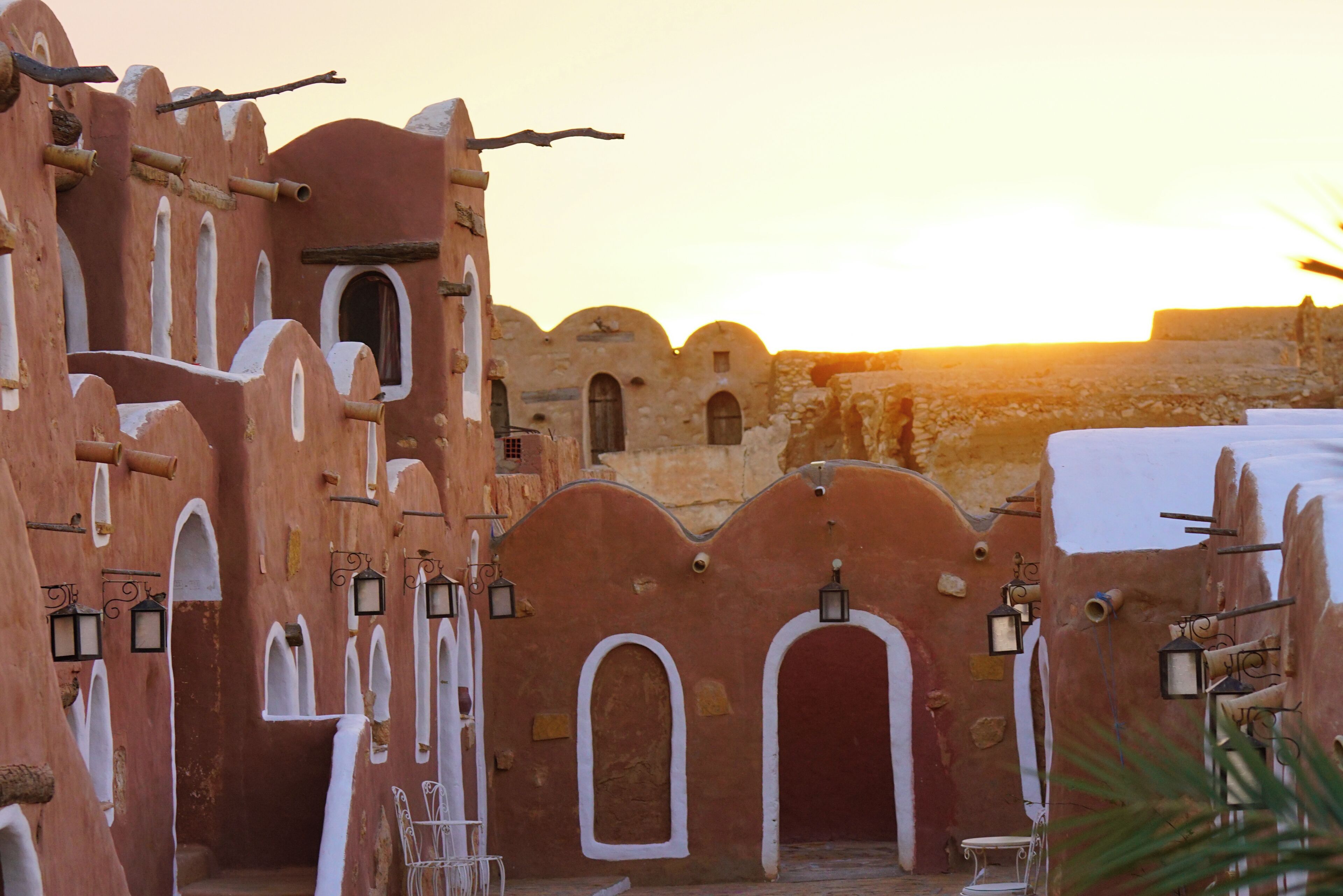 A traditional architectural structure with arched doorways and hanging lanterns, suggesting a historical or cultural setting.
