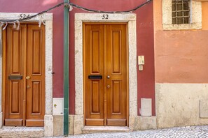 Two wooden doors with the number 52, a utility box, and a small window on a building facade. - Downtown Modern Apartments I by Homing (Lisbon)